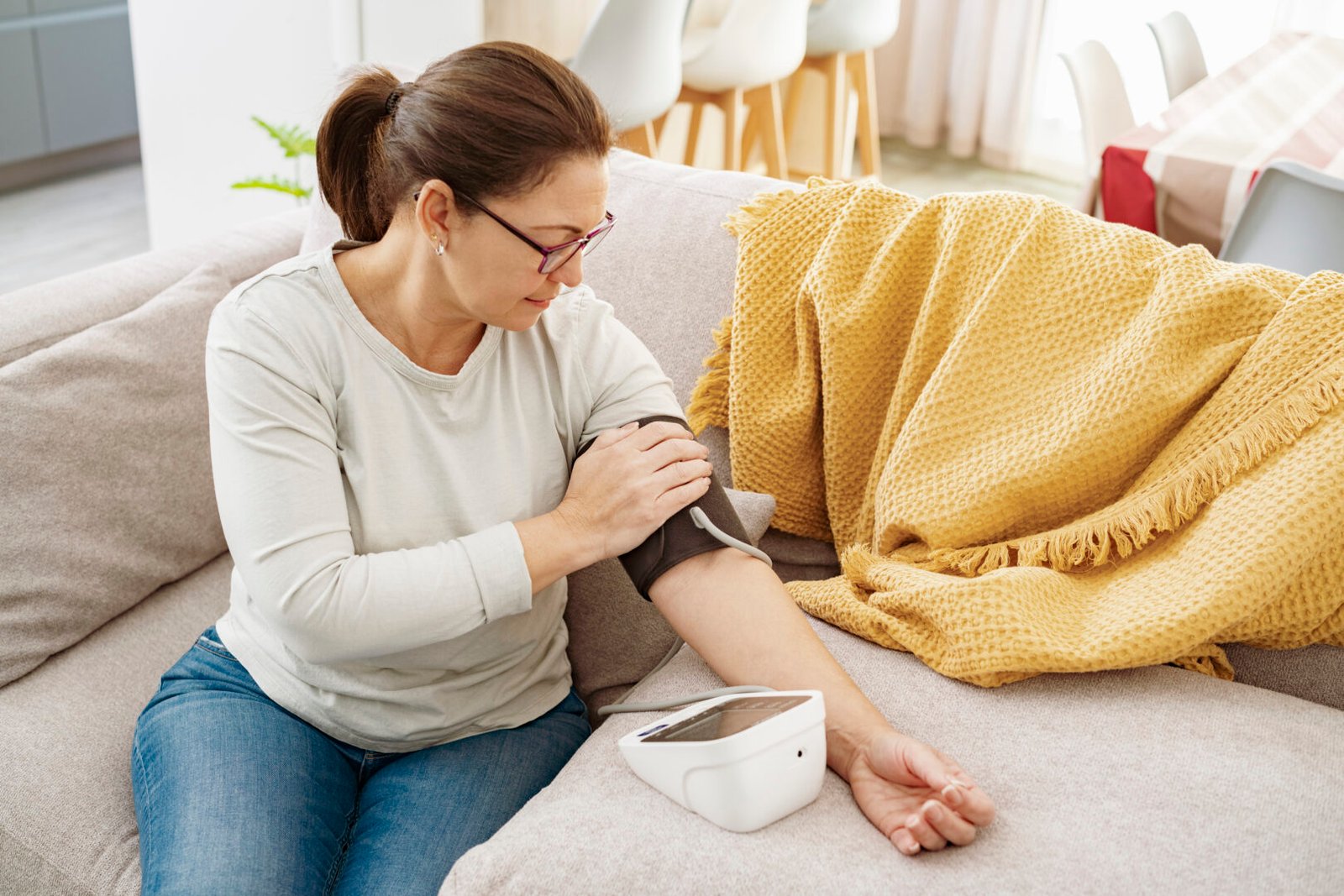 A woman checking her blood pressure at home.