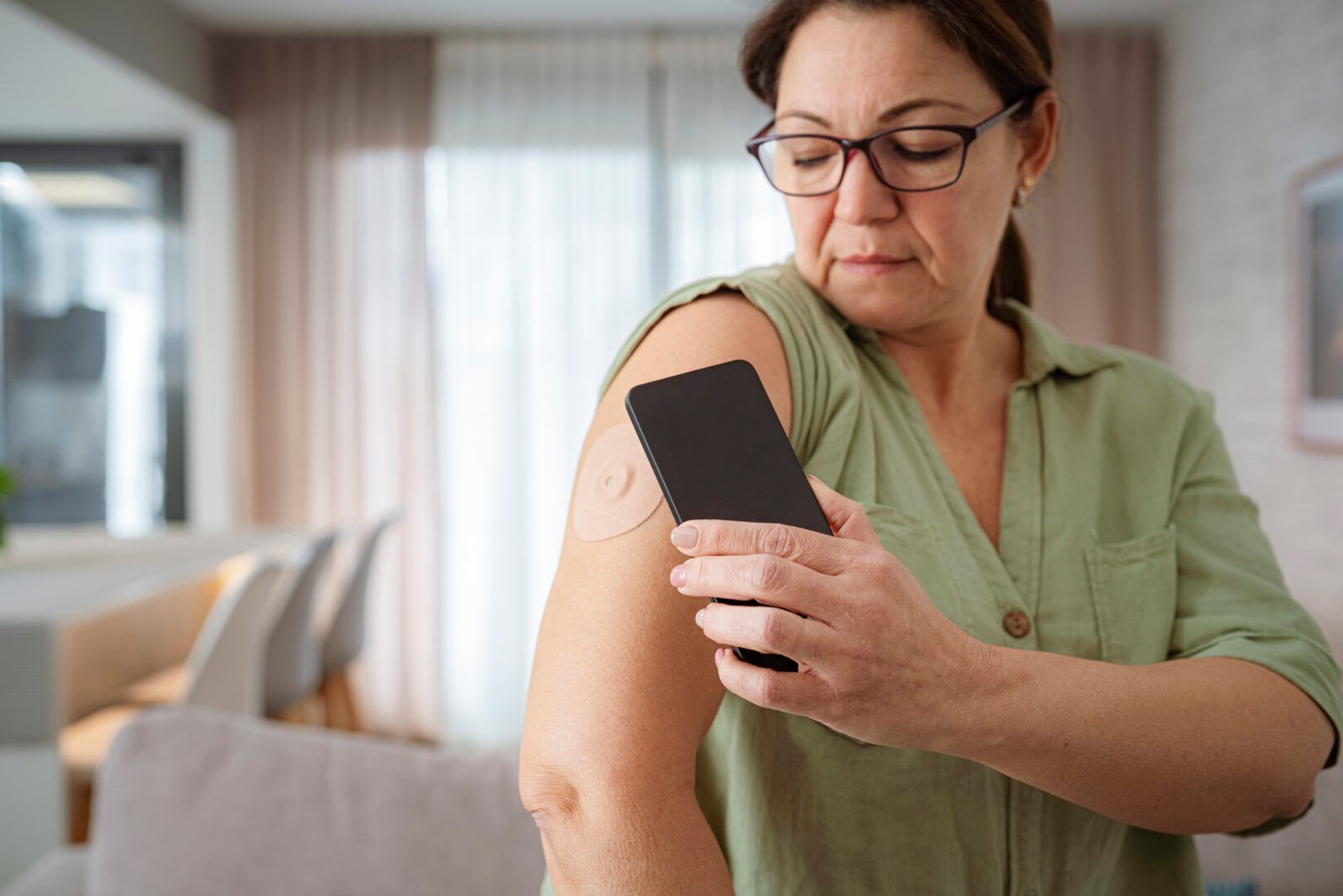 A woman with diabetes uses a CGM to check her blood glucose level.