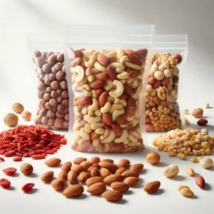 A studio photography of various types of nuts arranged on a white background. In the foreground, there are piles of red goji berries, brown almonds, and ivory cashew nuts, all unshelled and raw, spread out loosely. Behind them, three clear plastic resealable bags stand upright, filled with a mixture of walnuts, peanuts, and a medley of mixed nuts, showcasing shades of yellow, brown, and beige. The composition is well-lit with soft shadows, highlighting the natural textures and colors of the nuts.