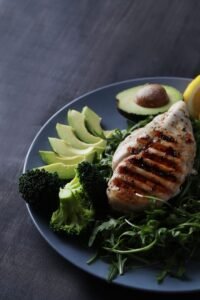A ketogenic meal of grilled chicken, avocado and broccoli. 