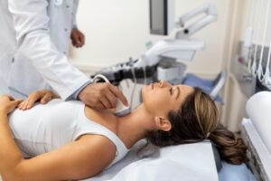 A woman is having a thyroid ultrasound imaging.
