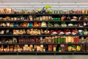 A shelf of packaged bread products in a grocery store.