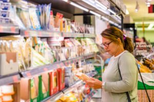 A woman examines the nutrition label of a grocery store product