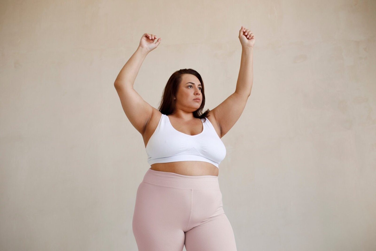 An obese young woman poses in workout clothes