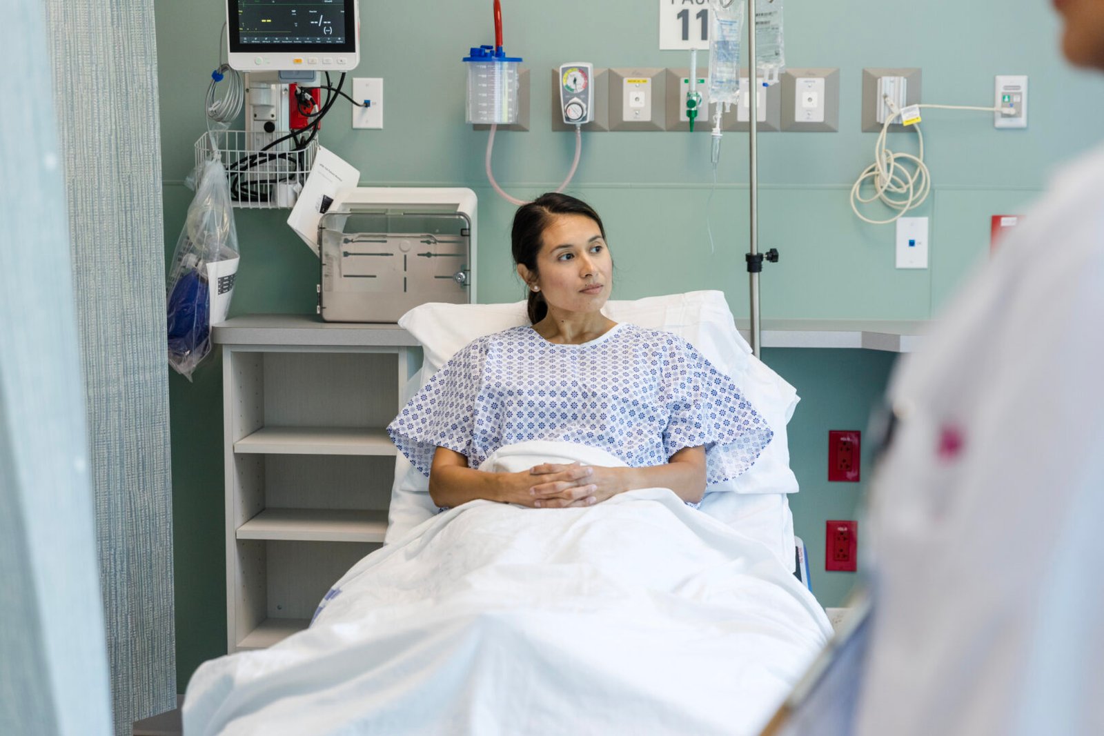 An Asian woman in a hospital bed